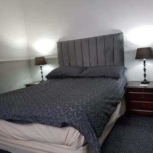 a bedroom with a large bed and two night stands at Binton Guest House in Filey