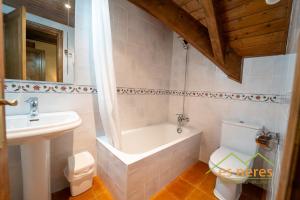 a bathroom with a tub and a sink and a toilet at Casa Es Neres in Les +30 photos
