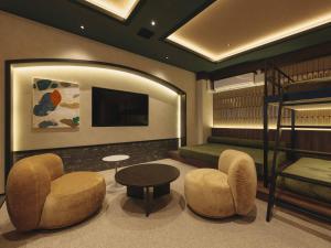 a room with a bunk bed and two chairs and a table at illi Harb Shibuya-Ebisu in Tokyo