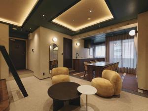 a living room with a table and chairs and a kitchen at illi Harb Shibuya-Ebisu in Tokyo