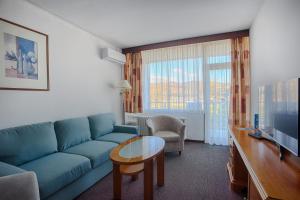 a living room with a blue couch and a table at Ensana Splendid in Piešťany