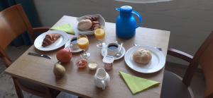 a table with plates of food and glasses of orange juice at Kabine 7 in Koksijde