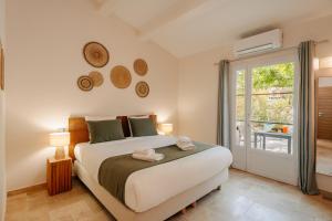 a bedroom with a large bed and a balcony at Les Maisons Du Sud in Saint-Tropez +82 photos