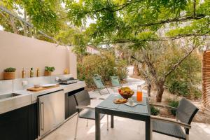 an outdoor kitchen with a table and chairs at Les Maisons Du Sud in Saint-Tropez