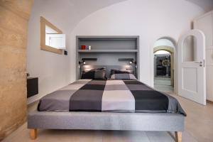 a large bed in a bedroom with white walls at Kore in Noto