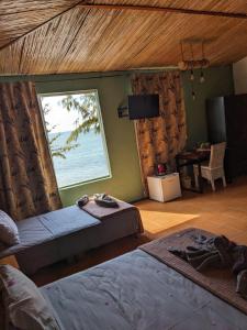 a bedroom with two beds and a large window at Bon Vivant Front de Mer - Ile Rodrigues in Rodrigues Island
