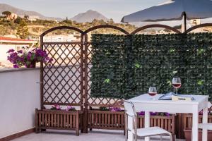 a table and chairs on a balcony with a fence at Casa vacanze Biondo in Trappeto