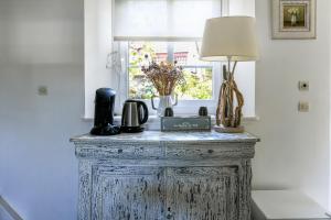 a table with a lamp on it in a room with a window at Cottages Croix Abbé, Bergeronnette in Saint-Valéry-sur-Somme
