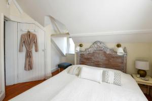 a bedroom with a bed and a dress hanging on a door at Cottages Croix Abbé, Bergeronnette in Saint-Valéry-sur-Somme