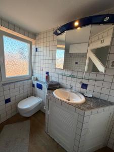 a bathroom with a sink and a toilet and a mirror at Über der Brücke in Melsungen +6 photos