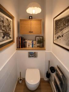 a bathroom with a toilet and a shelf with books at Le Touquet Beach, Front de Mer & Garage in Le Touquet-Paris-Plage +27 photos