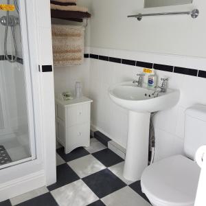 a white bathroom with a sink and a toilet at Binton Guest House in Filey