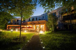 a building with lights in the grass in front of it at Heide Spa Hotel & Resort in Bad Düben
