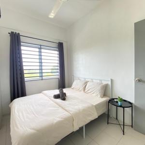 a bedroom with a white bed with a teddy bear on it at Sutra Impian Seaview Sutra Villa 2 in Kuantan +20 photos