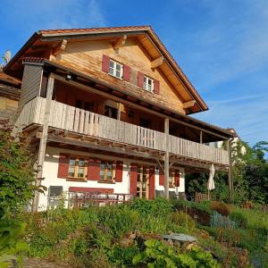 a large wooden house with a balcony on a hill at Ferienwohnung Landblick Lalling in Lalling