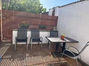 a patio with a table and chairs and a fence at Apartmán Vodolka in Odolena Voda