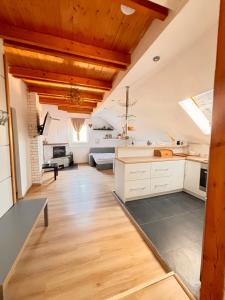 a large kitchen with white cabinets and wooden ceilings at Apartmán Pura Vida in Zaječí