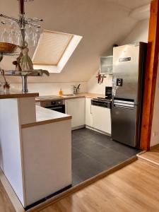 a kitchen with a stainless steel refrigerator and white cabinets at Apartmán Pura Vida in Zaječí +2 photos
