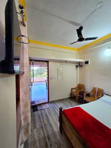 a bedroom with a bed and a living room at Nellakki Homestay in Madikeri