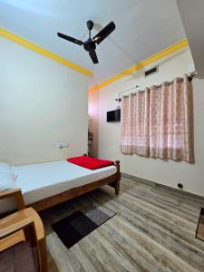 a bedroom with a bed and a ceiling fan at Nellakki Homestay in Madikeri
