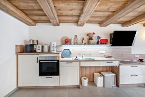 a kitchen with white appliances and wooden ceilings at Ferienwohnung Lausche in Hörnitz