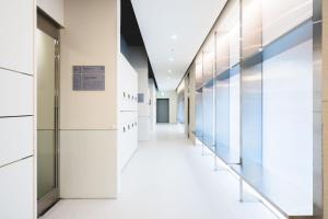 an empty hallway in a hospital with glass walls at Takt Jongno Female Only Capsule Hotel in Seoul