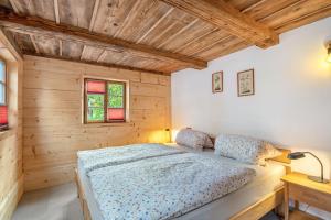 a bedroom with a bed in a wooden room at Ferienwohnung Lausche in Hörnitz
