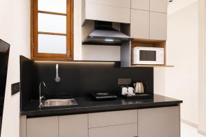 a kitchen with a sink and a microwave at Alaya Stays Luxora Suites, Golf Course Rd near galleria in Gurgaon