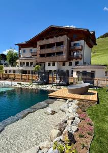 a house with a swimming pool and a building at Berghotel Alpenklang in Grossarl