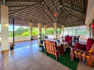 a living room with red chairs and a table at Nellakki Homestay in Madikeri