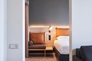 a bedroom with a bed and a chair and a couch at Moxy Essen City in Essen