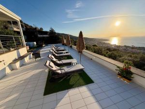 a row of lounge chairs and umbrellas on a balcony at Villa Ice Sorrento in Sorrento