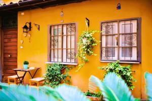 a yellow house with two windows and a table at The Best Nest in Rome