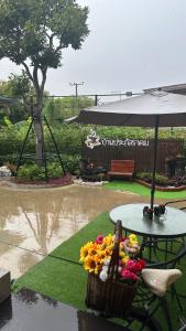 a table with a basket of flowers and an umbrella at บ้านประภัสราคม โฮมสเตย์ นครสวรรค์ in Ban Ko Ta Thep +7 photos