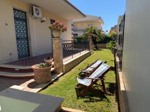 a yard with two lawn chairs and a house at Villa Aurea in Avola