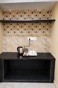 a black counter with cups and a pot on it at Ferro Livingz in Kumbalgod