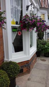 a window with flowers on the side of a building at Binton Guest House in Filey