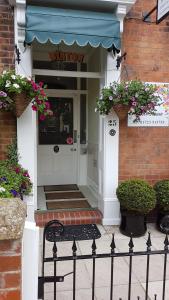 a store front with a doorway with flowers in front of it at Binton Guest House in Filey +13 photos