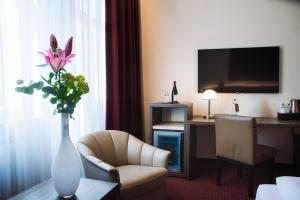 a hotel room with a vase of flowers on a table at Hotel Prinzregent in Nuremberg