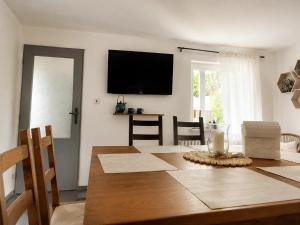a dining room with a table and a television on the wall at Seč Aktivně in Seč