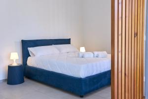 a bedroom with a blue bed with two pillows at Dara Holiday Apartments in Marsala