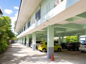 an empty building with cars parked in a parking lot at โรงแรม วี เฮาส์ ณ คอน in Nakhon Si Thammarat