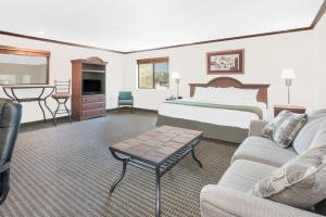 um quarto de hotel com uma cama e uma sala de estar em Days Inn by Wyndham Mitchell SD em Mitchell