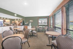 a waiting room with tables and chairs and windows at Days Inn by Wyndham Mitchell SD in Mitchell