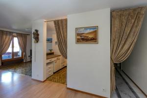 an empty living room with curtains and wooden floors at Edelweiss in Charmey