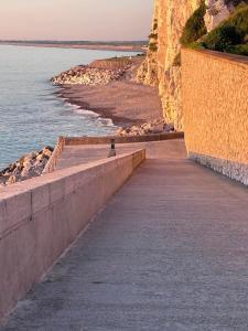 a person walking on a retaining wall next to the water at Aulta in Ault