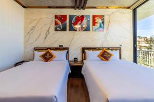 two beds sitting next to each other in a room at khách sạn phúc hải in Da Lat