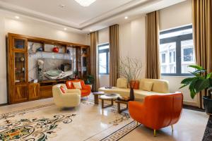 a living room with a couch and chairs and a tv at AuraLite Hotel - Panorama View Đà Lạt in Da Lat