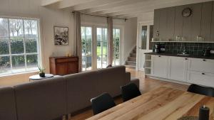 a living room with a couch and a table at Ruime Vakantiewoning - Hoeve Niets meer - met eigen privé terras en tuin in Balkbrug