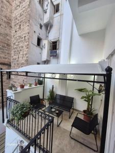 a balcony with chairs and a table and some plants at La Casa del Faro in Taranto